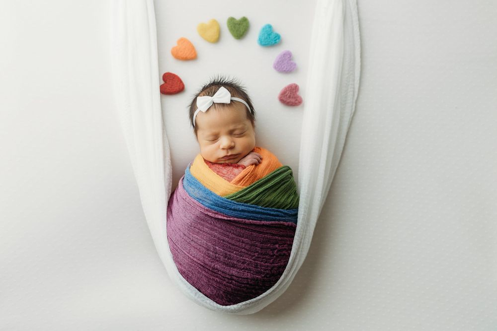 Colorful yarn balls in glass jars decorated with heart-shaped stickers create a charming crafting display.