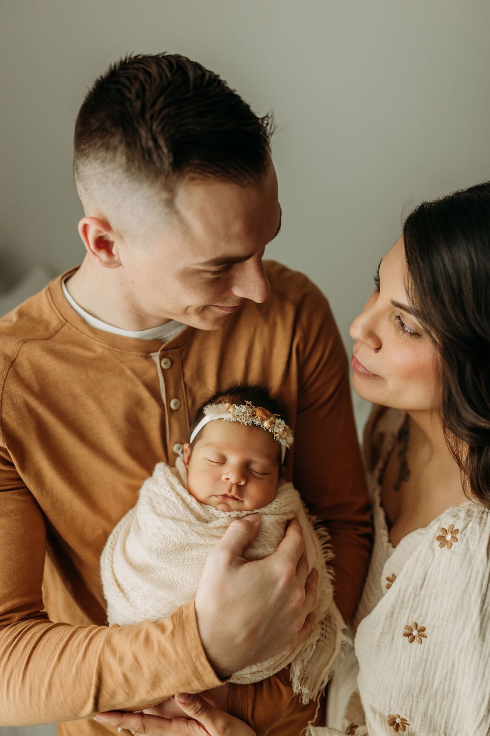 A tender family moment captured in a series of intimate indoor portraits with warm brown and white tones.