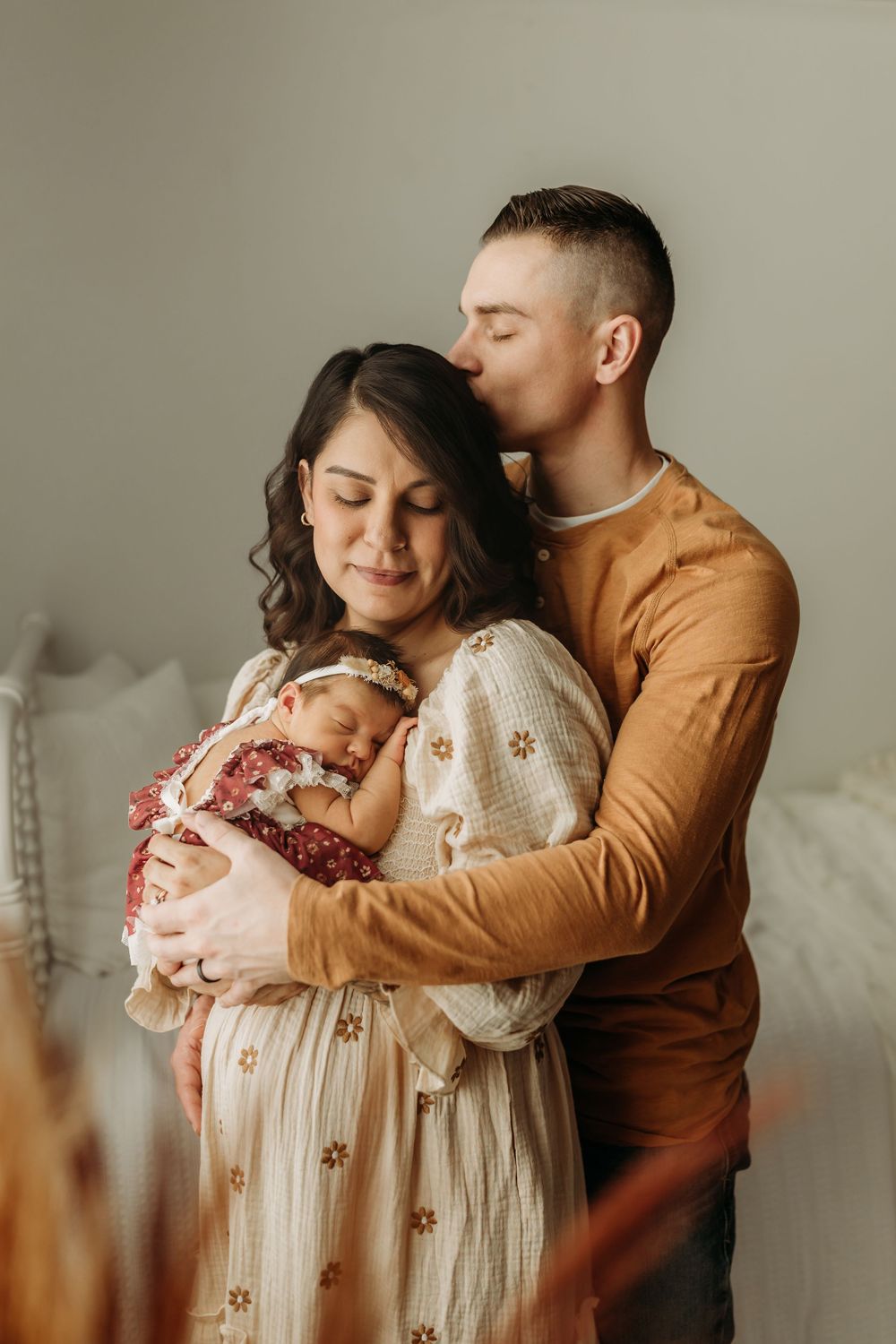 Intimate family moment with parents embracing their newborn baby.
