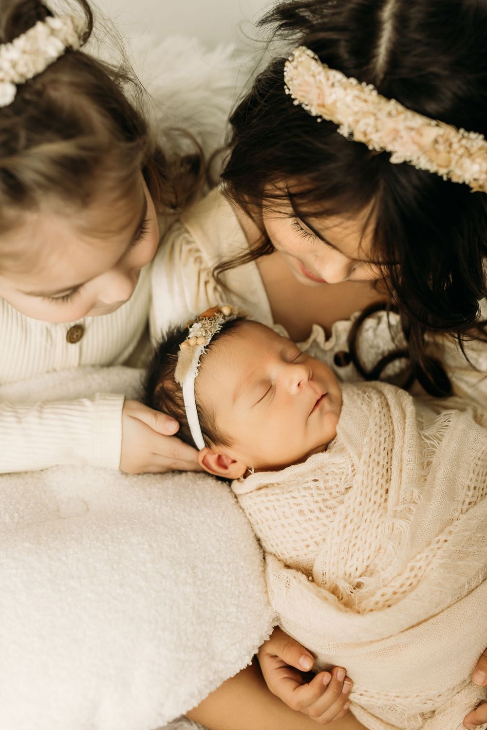A tender moment captured in soft lighting as a baby sleeps peacefully in white bedding.