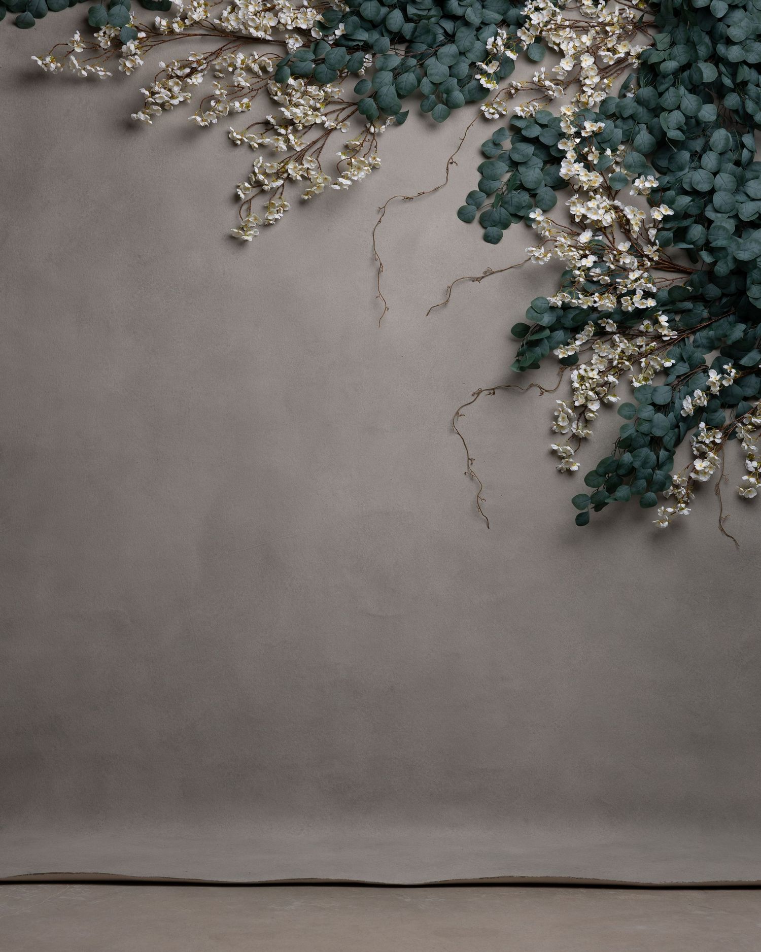 Ethereal studio backdrop with sheer white fabric draping and small silver Christmas trees creating a dreamy winter scene.