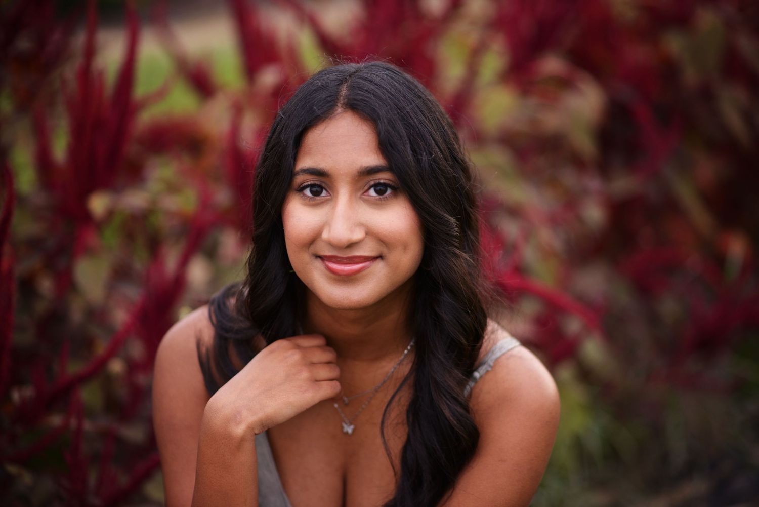 A series of outdoor portrait photos featuring dark hair against vibrant red autumn foliage in natural lighting.
