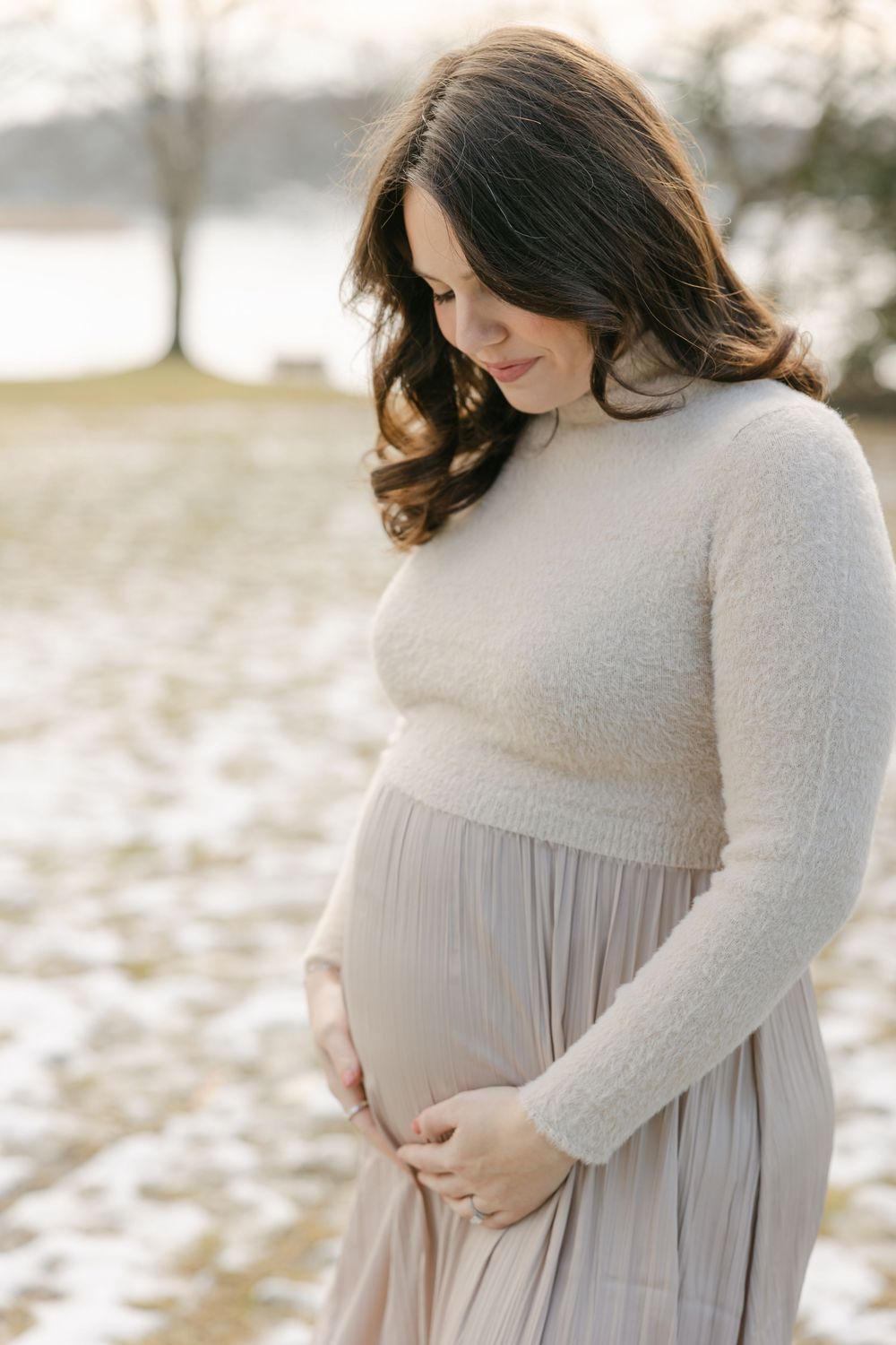 A series of maternity portraits showing a woman in a flowing beige dress against a snowy outdoor backdrop. Hartford Photography