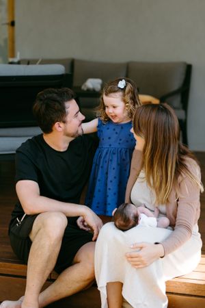 Happy family sharing joyful moment together on wooden bench indoors.