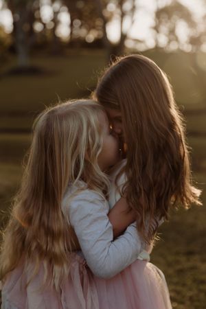 Intimate moment between parent and child in golden sunset light.