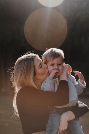 Beautiful backlit mother and child portrait in outdoor setting.