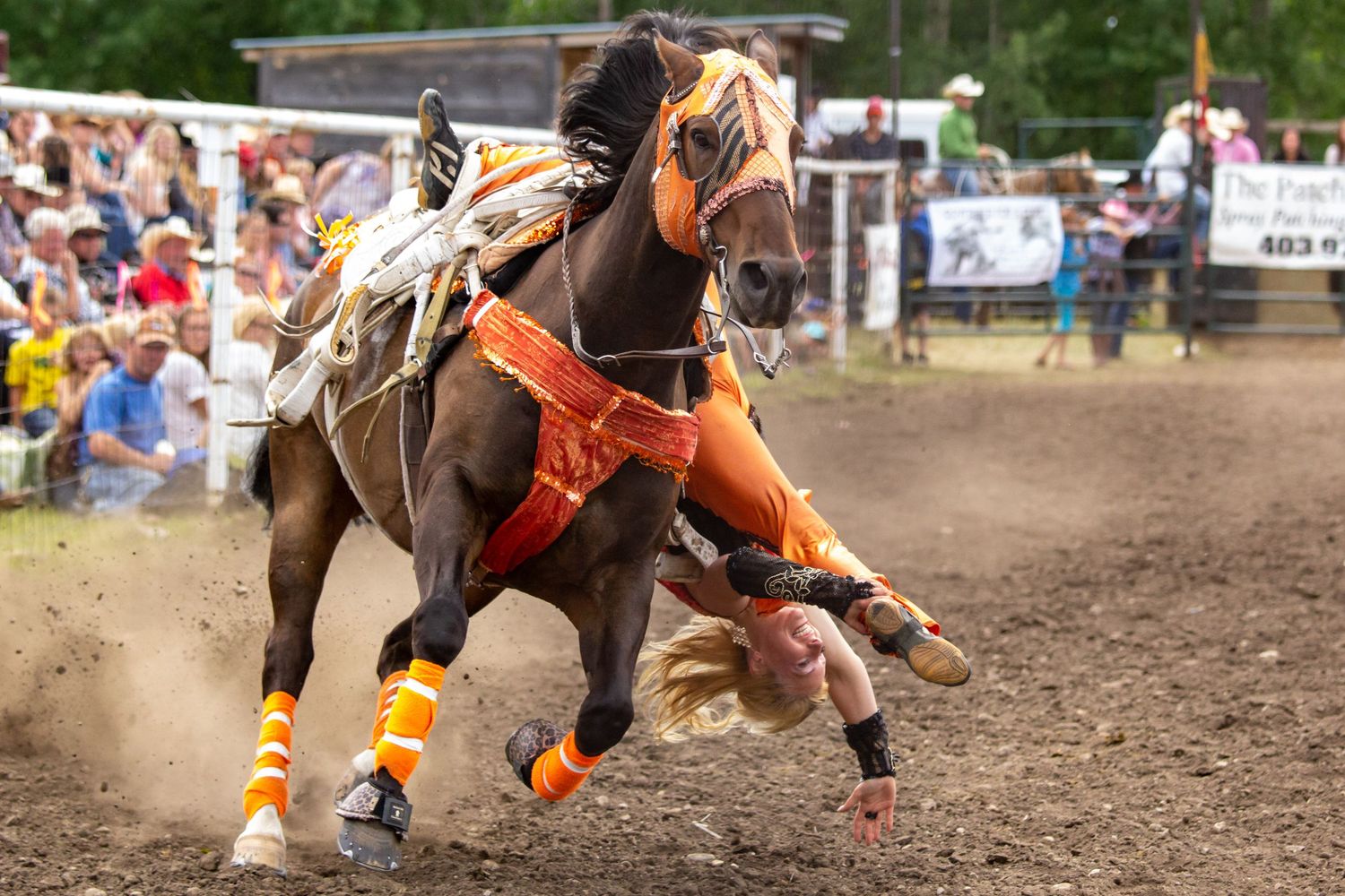 A horse and rider performing a barrel racing pattern at a rodeo competition in an outdoor arena.