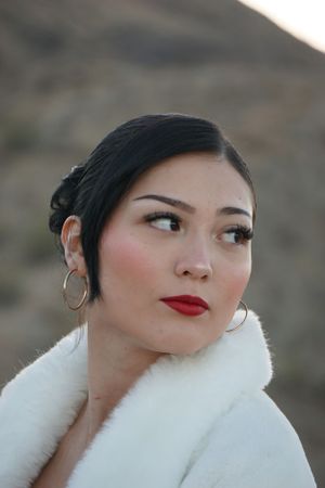 Portrait of a woman wearing a white fur collar and red lipstick.