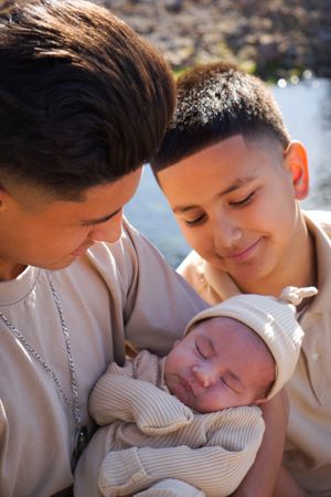 Tender moment with newborn baby being held and kissed.