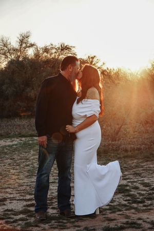 Romantic couple embracing in desert landscape during sunset.