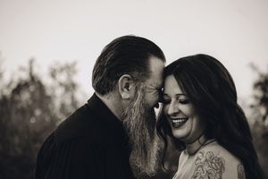 Intimate black and white portrait of a couple sharing a joyful moment outdoors.