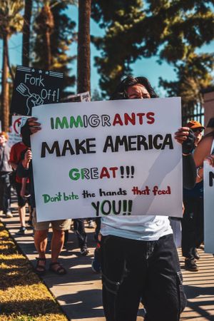 Pro-immigrant protest signs at a rally showing messages of support and inclusion.
