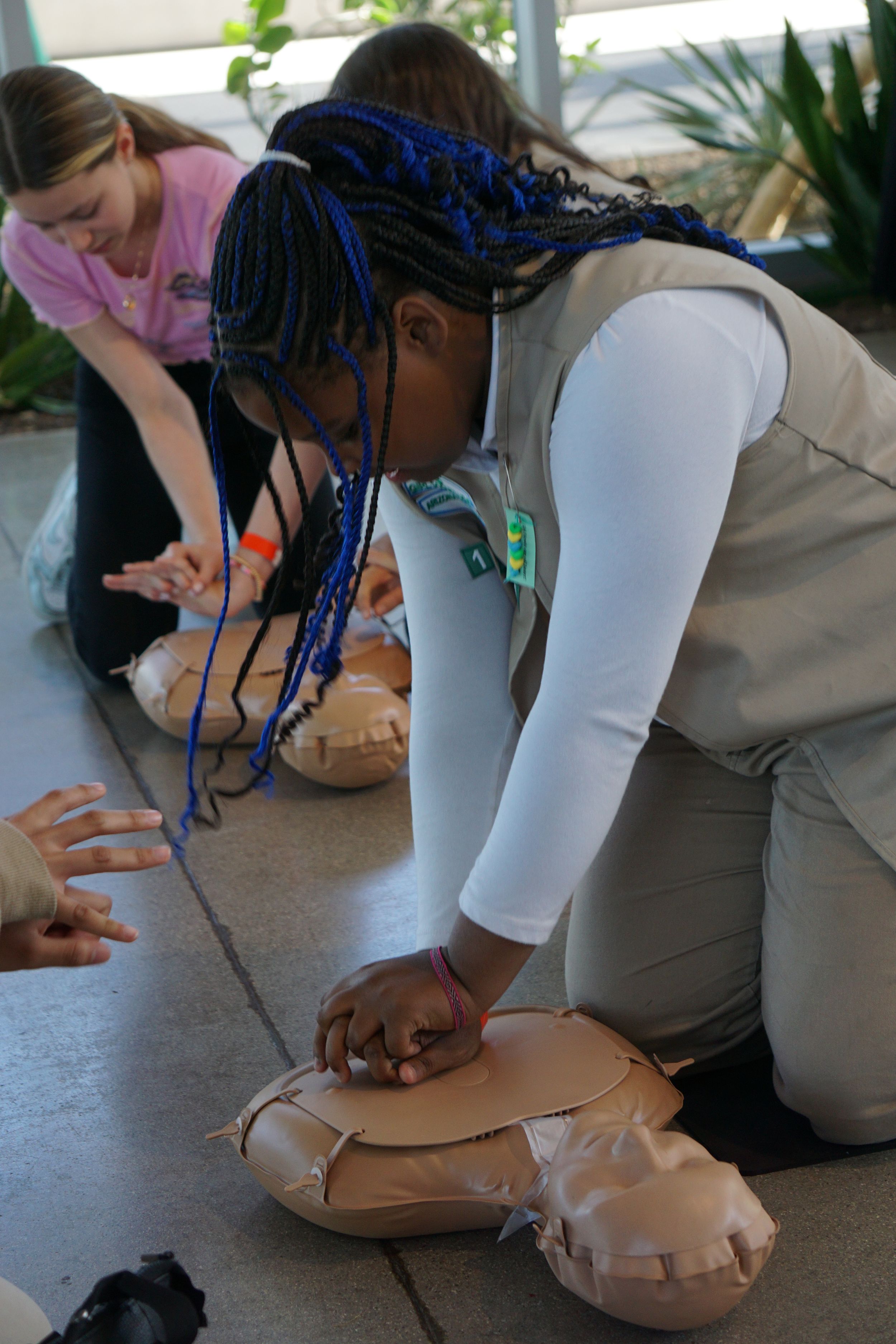 People practicing CPR techniques on training mannequins during a first aid class.