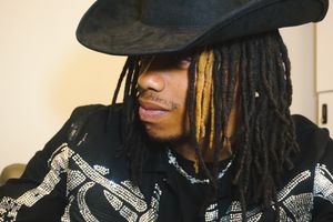 Close-up profile view of someone wearing a black hat in natural lighting.