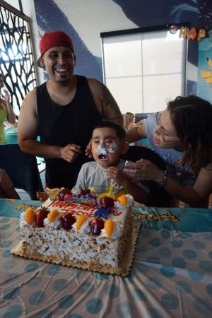 People gathered around a decorated cake at a celebration party.