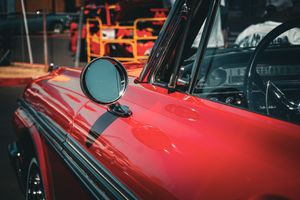 Detail shots of a classic red car exterior under dramatic lighting.