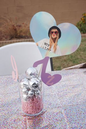 Decorative butterfly ornaments with silver bows on a confetti-covered surface.