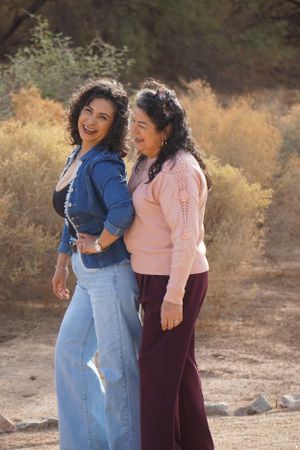Two people sharing joyful moments outdoors in casual attire.
