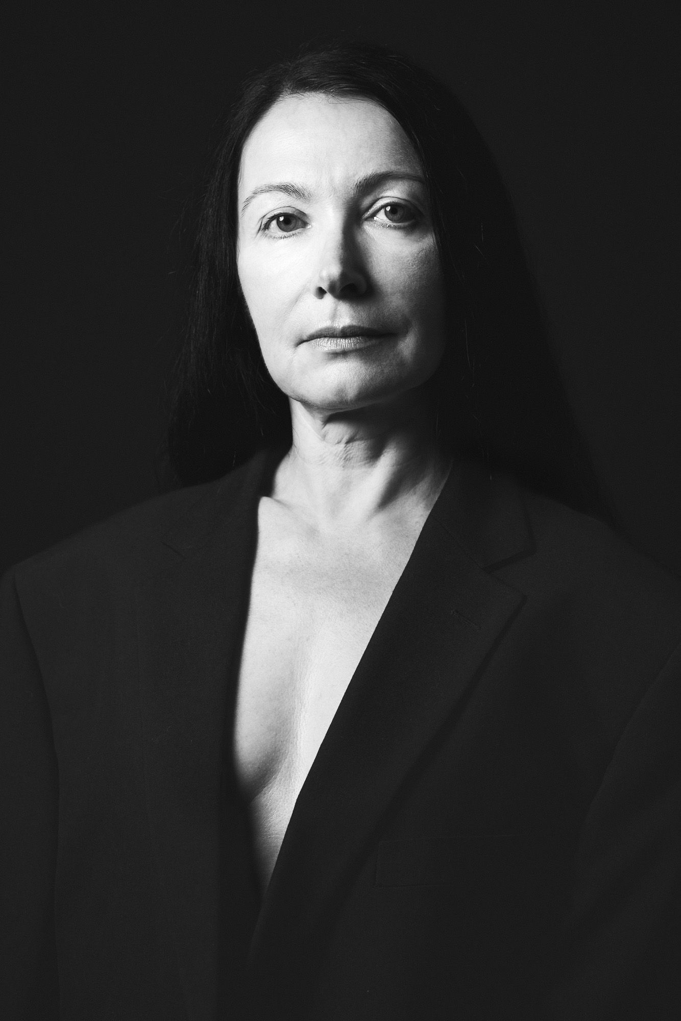 black and white portrait of a confident woman in a black blazer taken by N-lite photography in a studio in King's Lynn, Norfolk