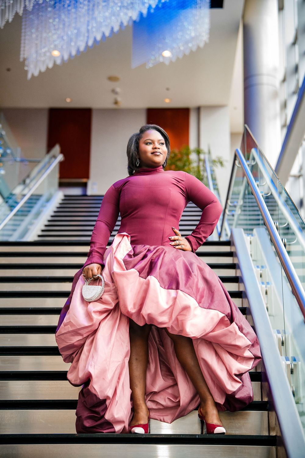 Series of photos showing a flowing pink and burgundy dress twirling on stairs with decorative white snowflakes above.