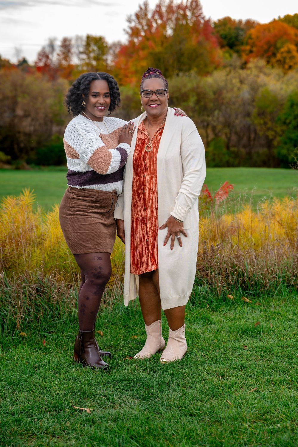 Outdoor autumn photoshoot in a field with warm earth tones and natural fall foliage.