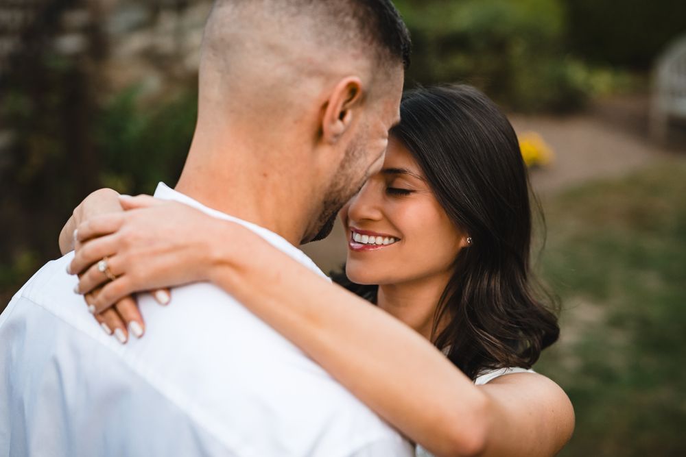 Couple shares loving embrace during sunset garden photography session.