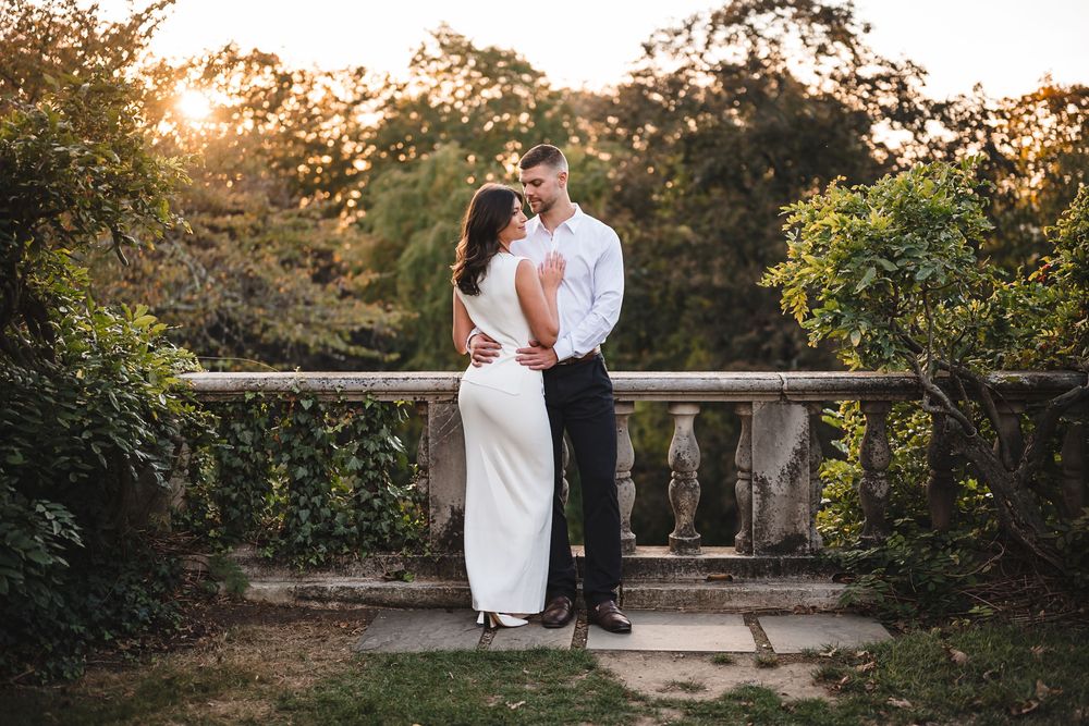 Romantic sunset photoshoot in a garden setting with golden light filtering through trees.