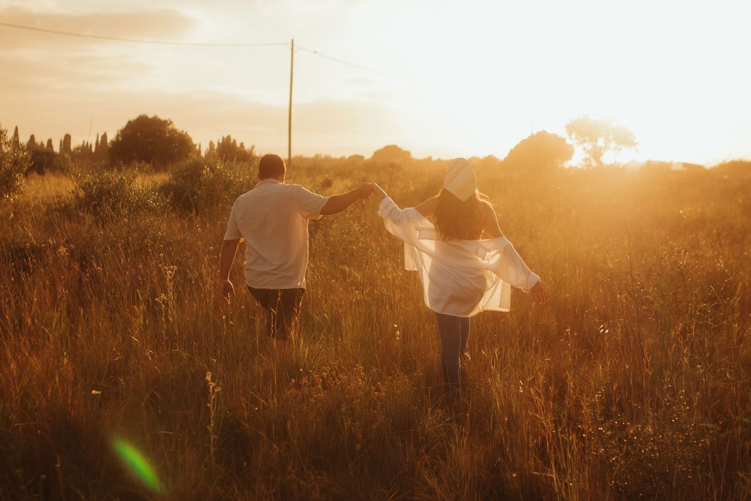 Pareja embarazada caminando de espaldas al atardecer en el campo en Tarragona