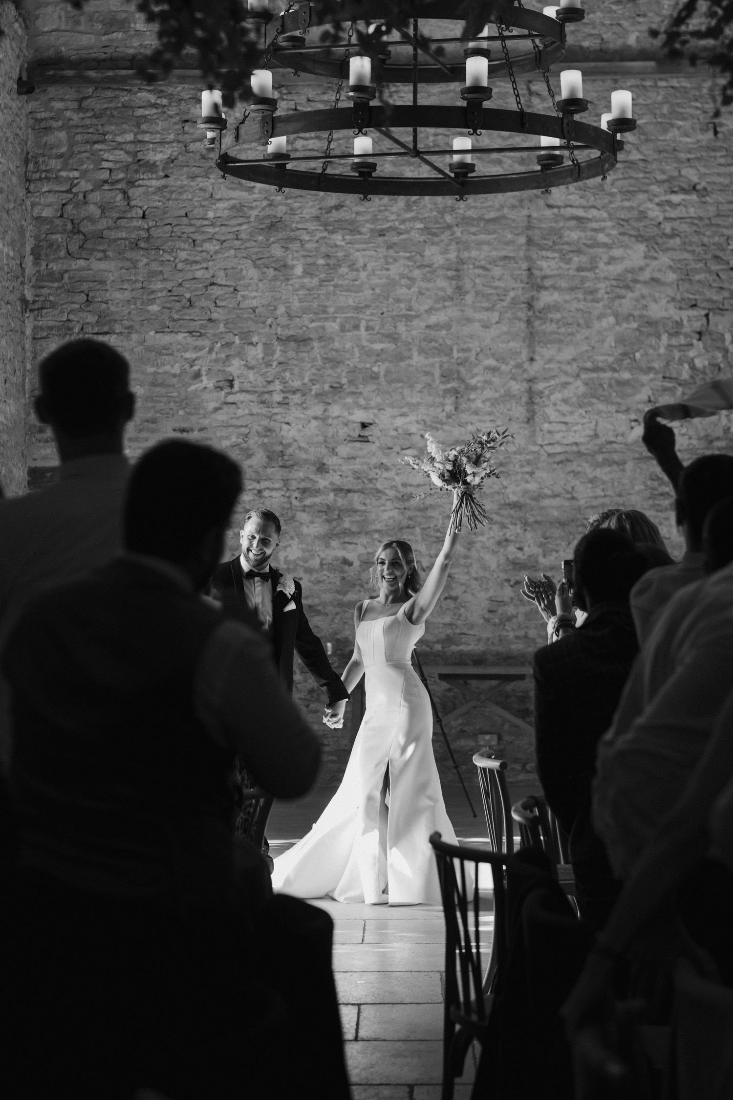 bride and groom entering the wedding breakfast barn cheering at ivy lodge in cirencester