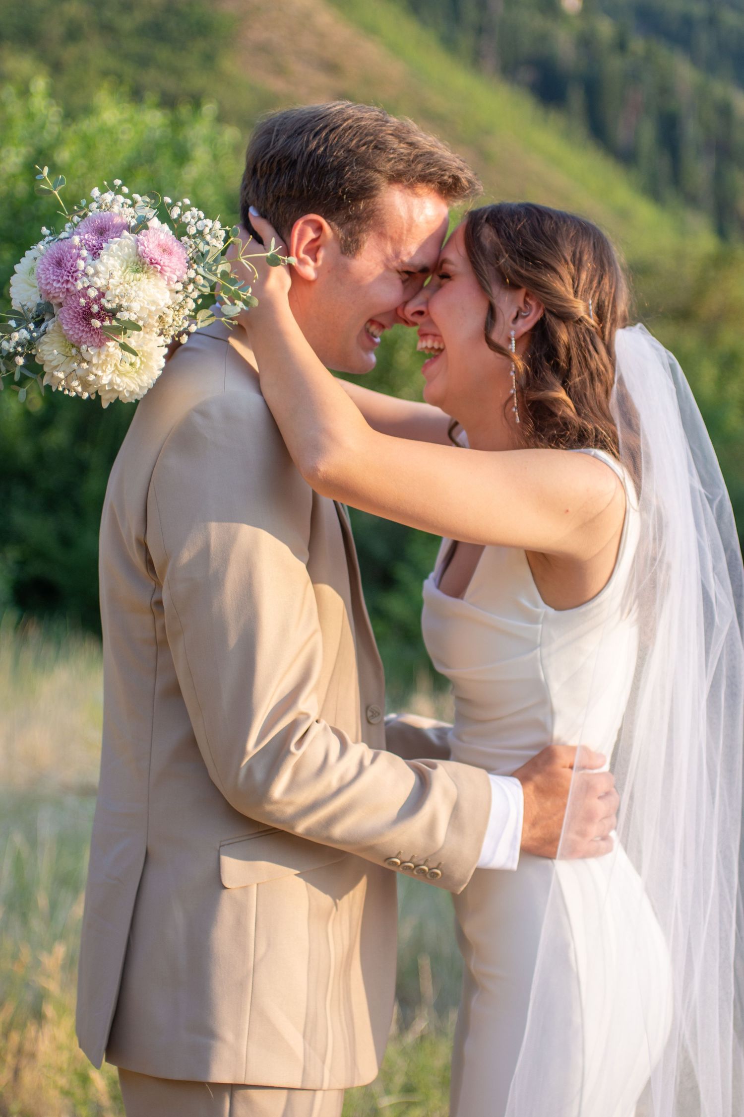 A romantic wedding sequence shows a couple kissing in a beautiful outdoor mountain setting with white flowers and veil.