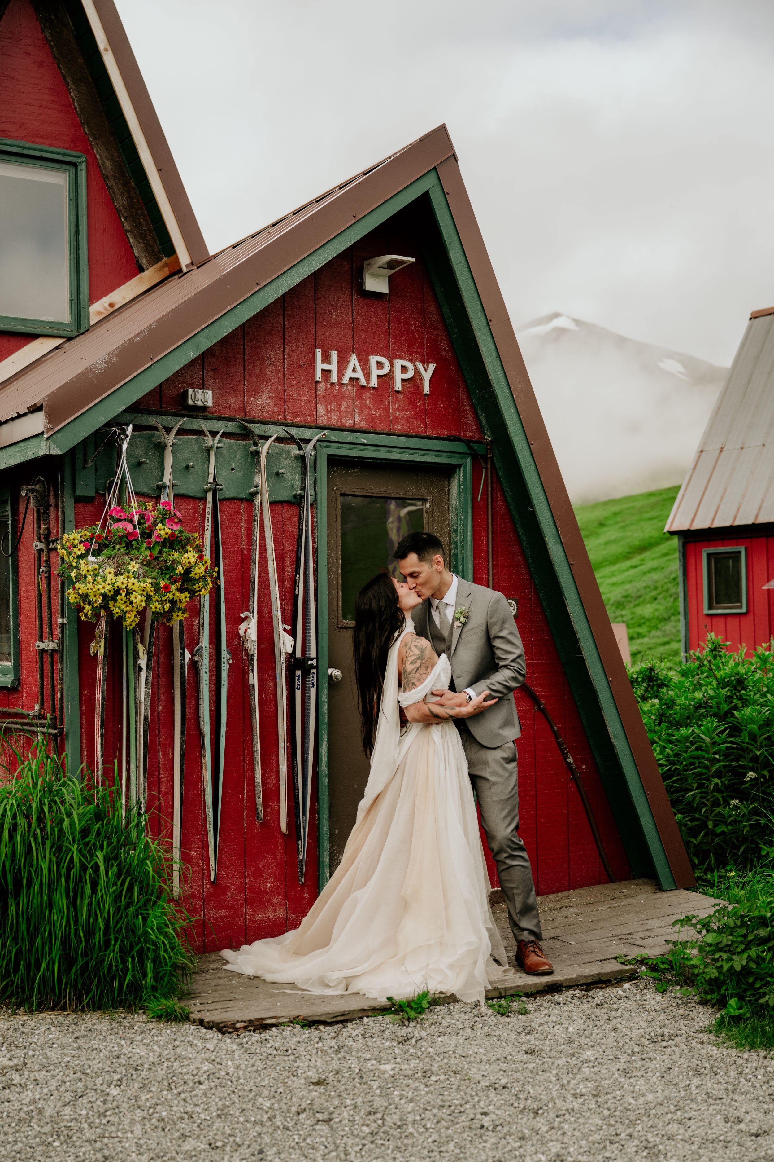 Romantic wedding photos in front of a charming red A-frame cabin.