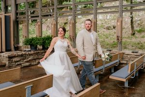 Wedding couple sharing moments in a rustic outdoor venue with wooden beams.