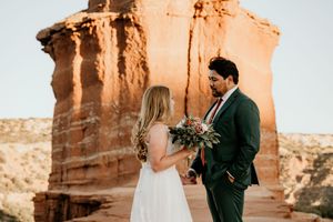 A couple exchanging vows during their ceremony at a scenic mountain overlook.
