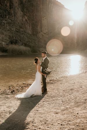 Sunset wedding photos in a canyon with dramatic lens flare and long shadows.