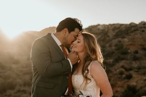 Romantic sunset wedding portrait against a mountain backdrop.