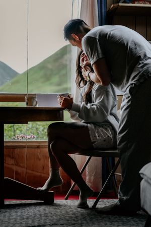 A cozy morning scene of someone enjoying coffee by a window with mountain views.
