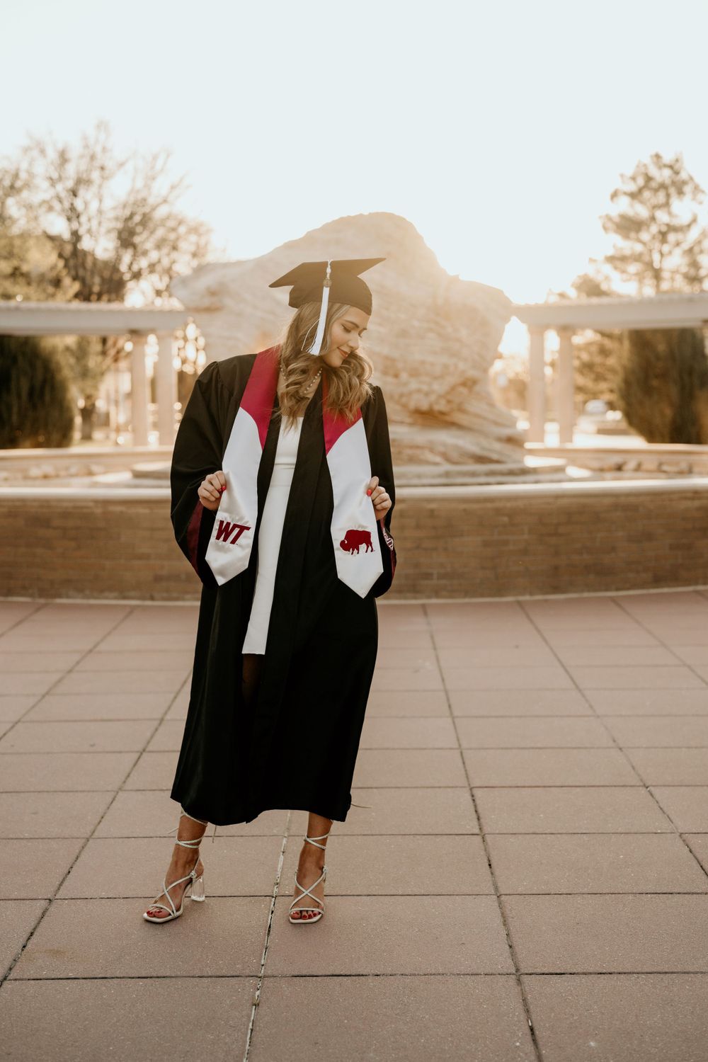Graduation photos showing details of cap and gown against sunset lighting.