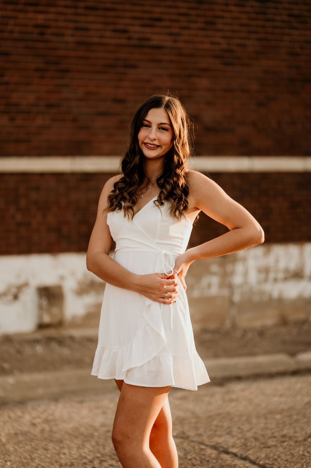 A series of dynamic poses in a white outfit against a brick wall background.