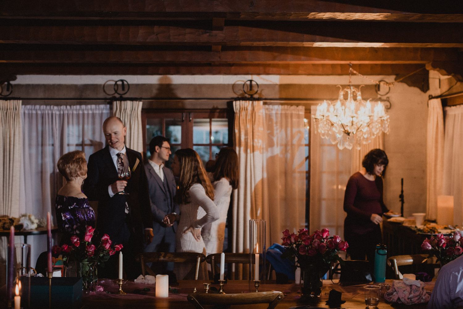 A series of wedding reception photos showing elegant chandelier lighting and guests mingling in a warm, romantic venue.