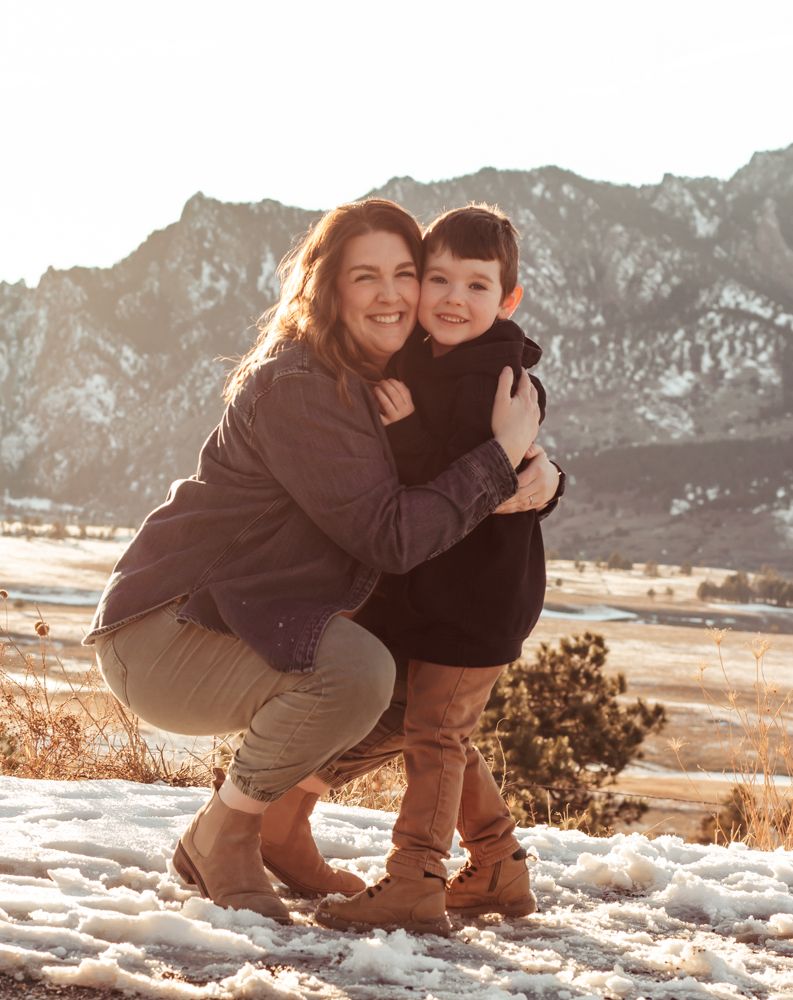 A happy family embraces outdoors during golden hour in a natural setting with tall grass and trees | How I Help You Prep for Family Photos