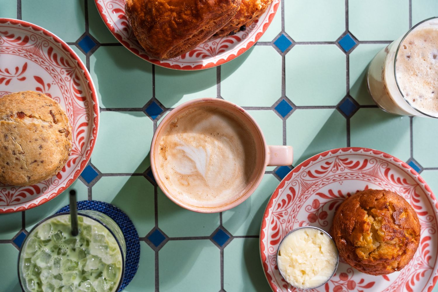 A flat lay shot of breakfast pastries and cafe drinks on a tiled table at an outdoor cafe at an Atlanta Hotel