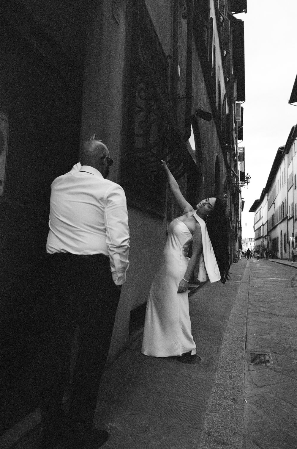 A sequence of black and white photos showing two people walking down an Italian street with dramatic shadows.