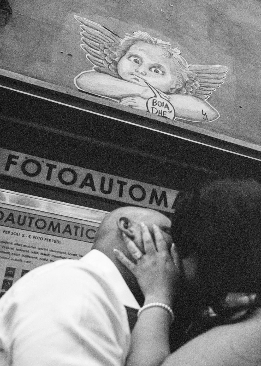 Black and white photograph showing people reaching for a cigarette vending machine in what appears to be a subway station.