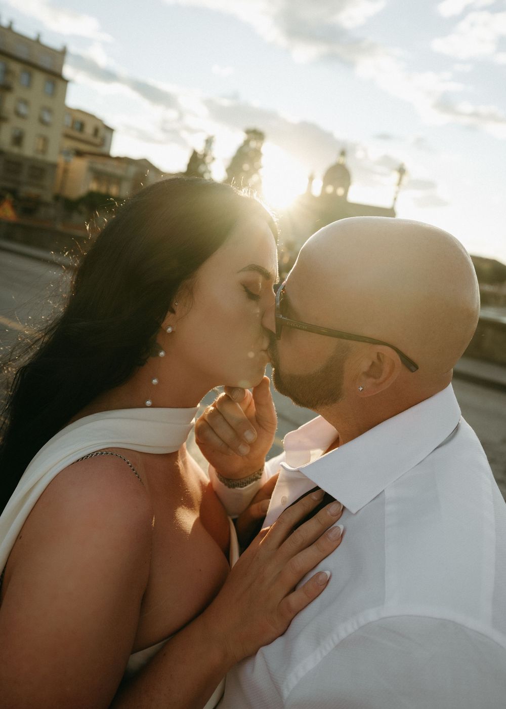 A romantic couple shares an intimate moment at sunset, with golden light illuminating their silhouettes.