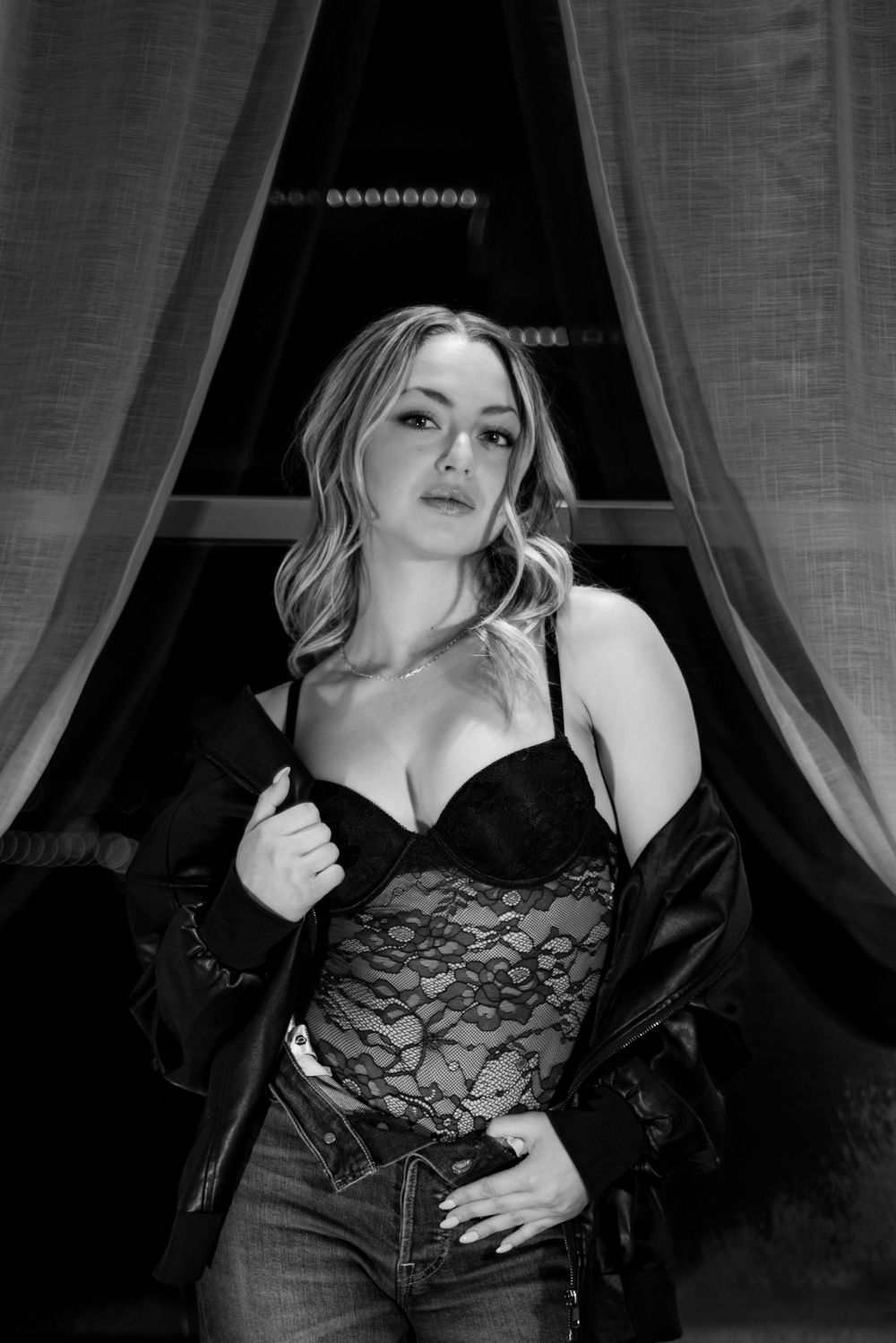 Artistic black and white boudoir photo series showing a figure in lace against draped fabric backdrop.