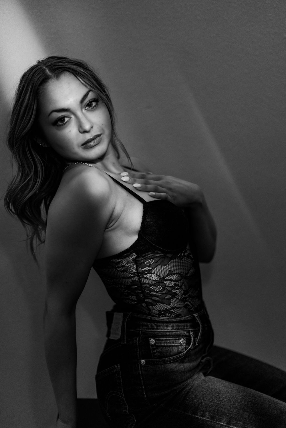 Artistic black and white portrait series showing a figure in dark clothing against a shadowy background.