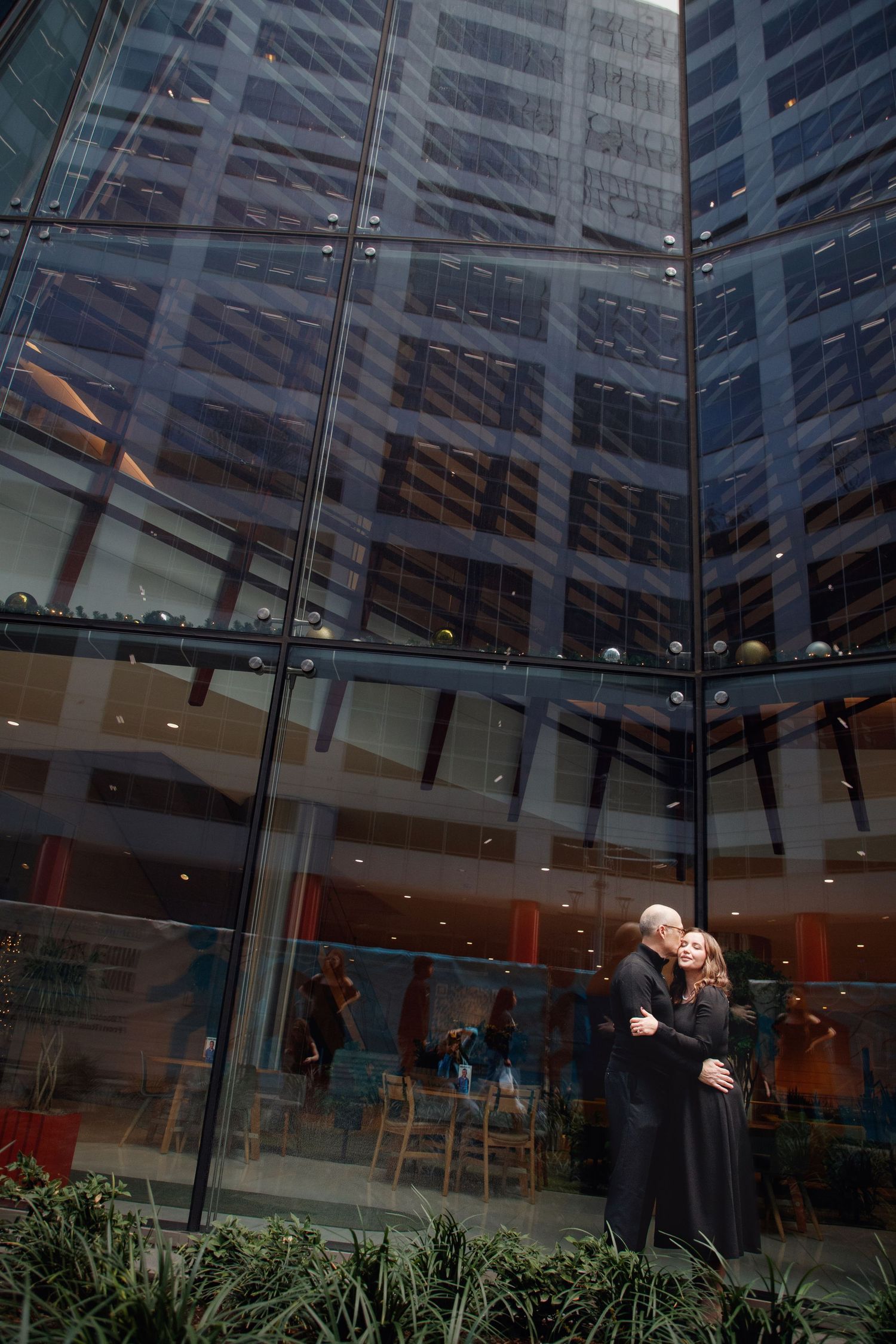 Urban couple photography on Main Street in downtown Houston with city reflections and modern style