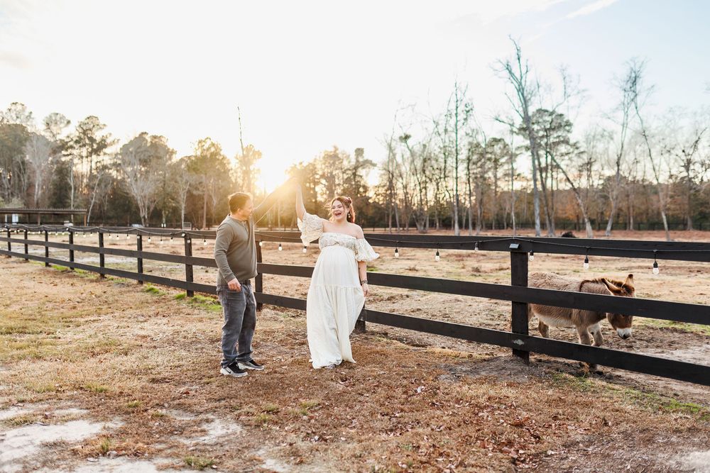 A romantic sunset engagement session captured in a rustic farm setting with wooden fences and golden light.