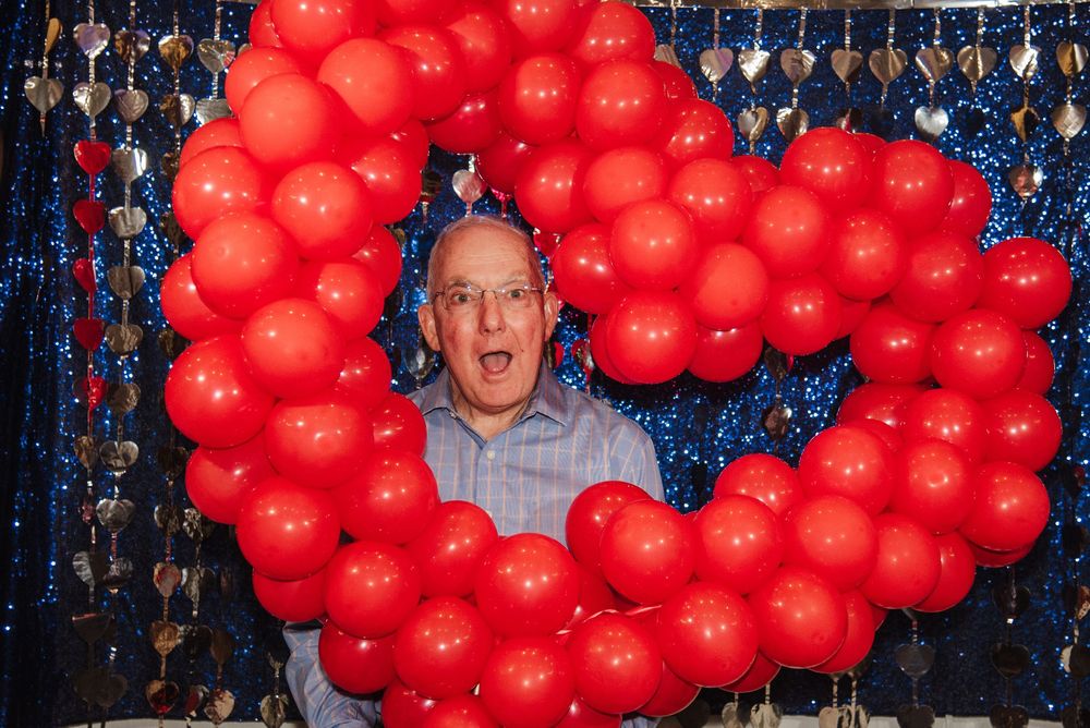 A sequence of photos shows someone reacting with increasing surprise as red balloons accumulate around them.