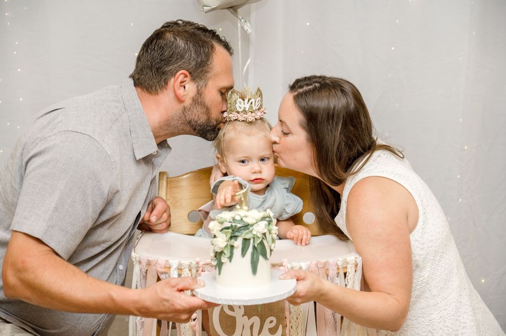 Family sharing sweet moments together while enjoying birthday cake during a first birthday celebration photoshoot.